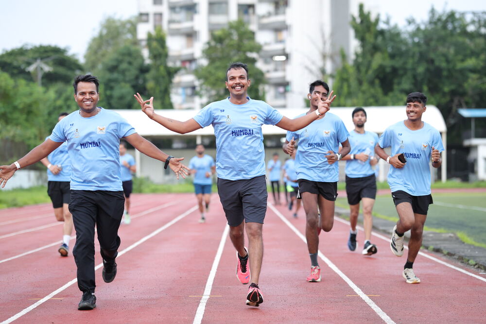 Runners cheering with victory signs on the track