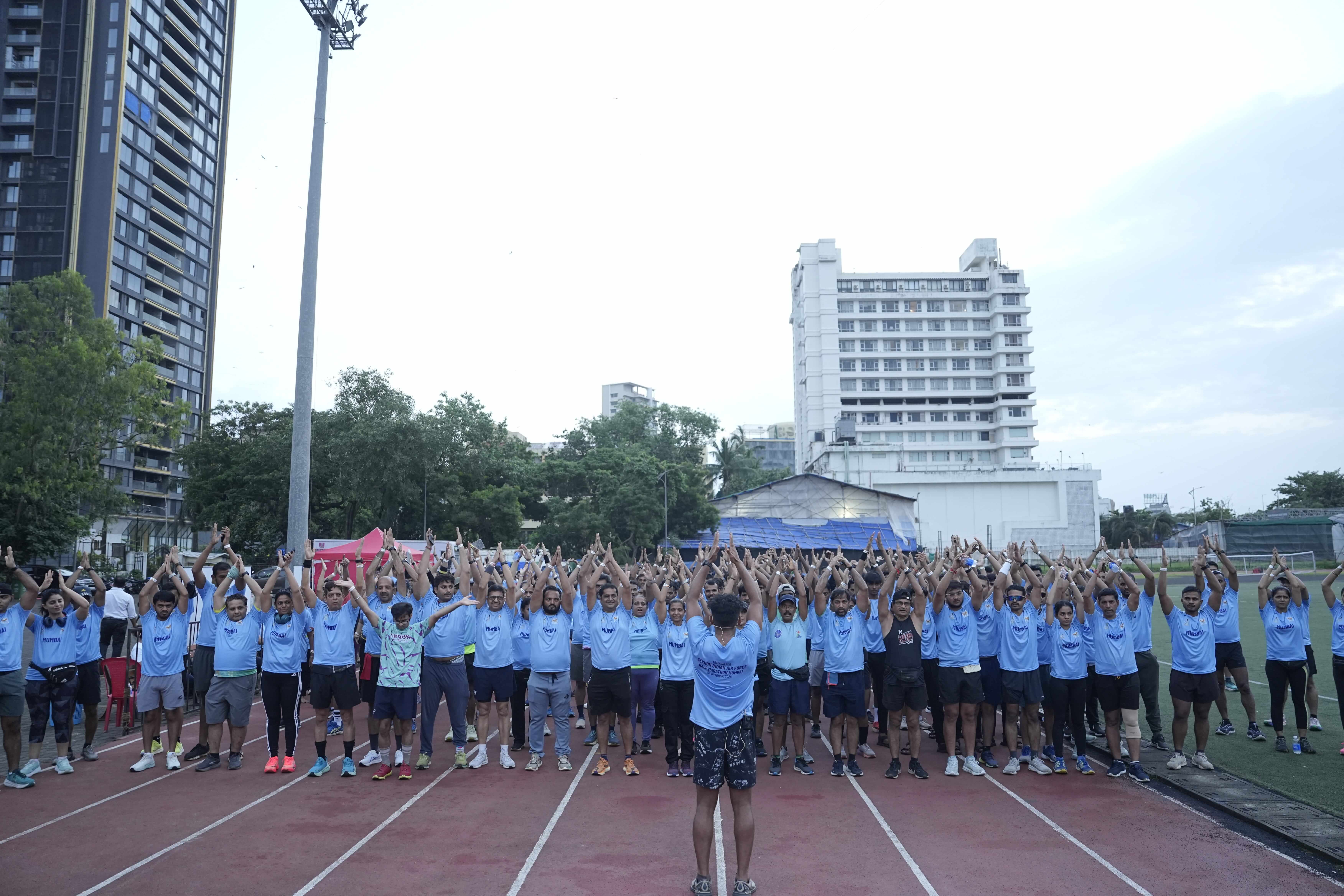 Massive group stretching arms high toward sky before race